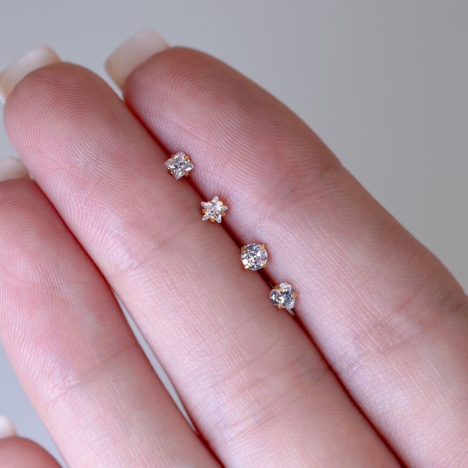 Piercing do nosu zahnutý do "L" s různými motivy a v různých barvách