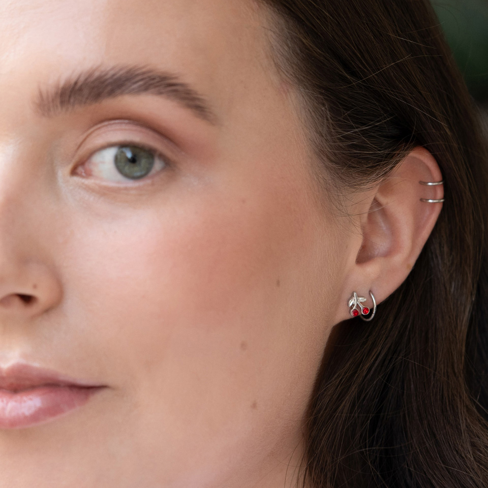 Tragus piercing s červenými třešněmi