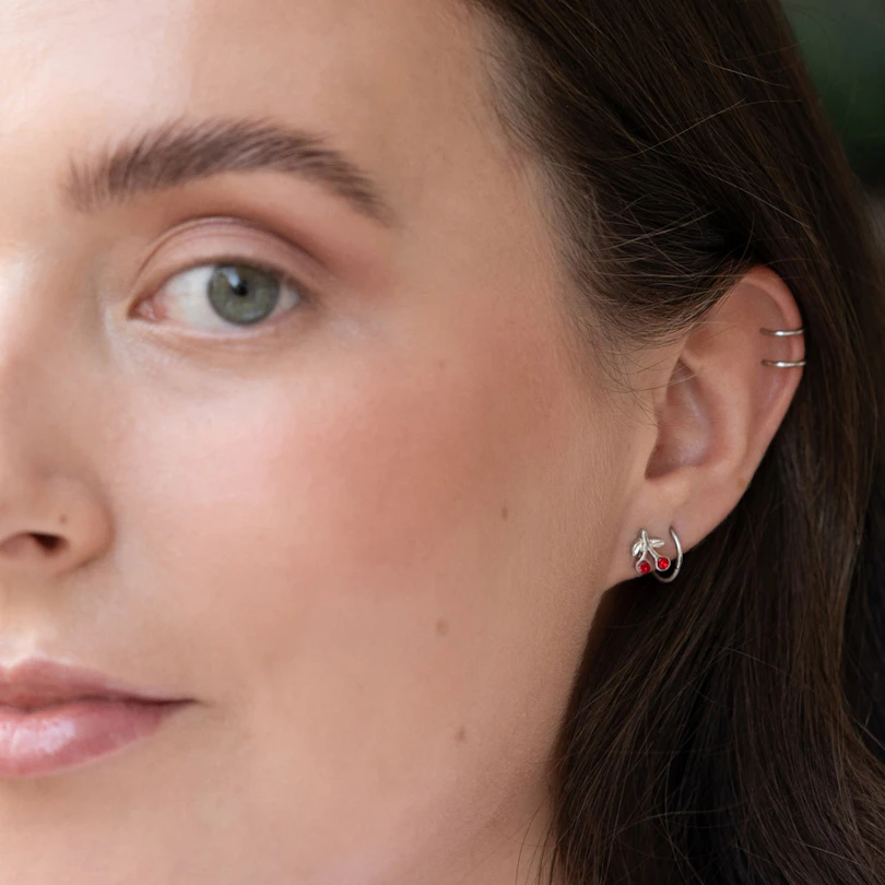 Tragus piercing s červenými třešněmi