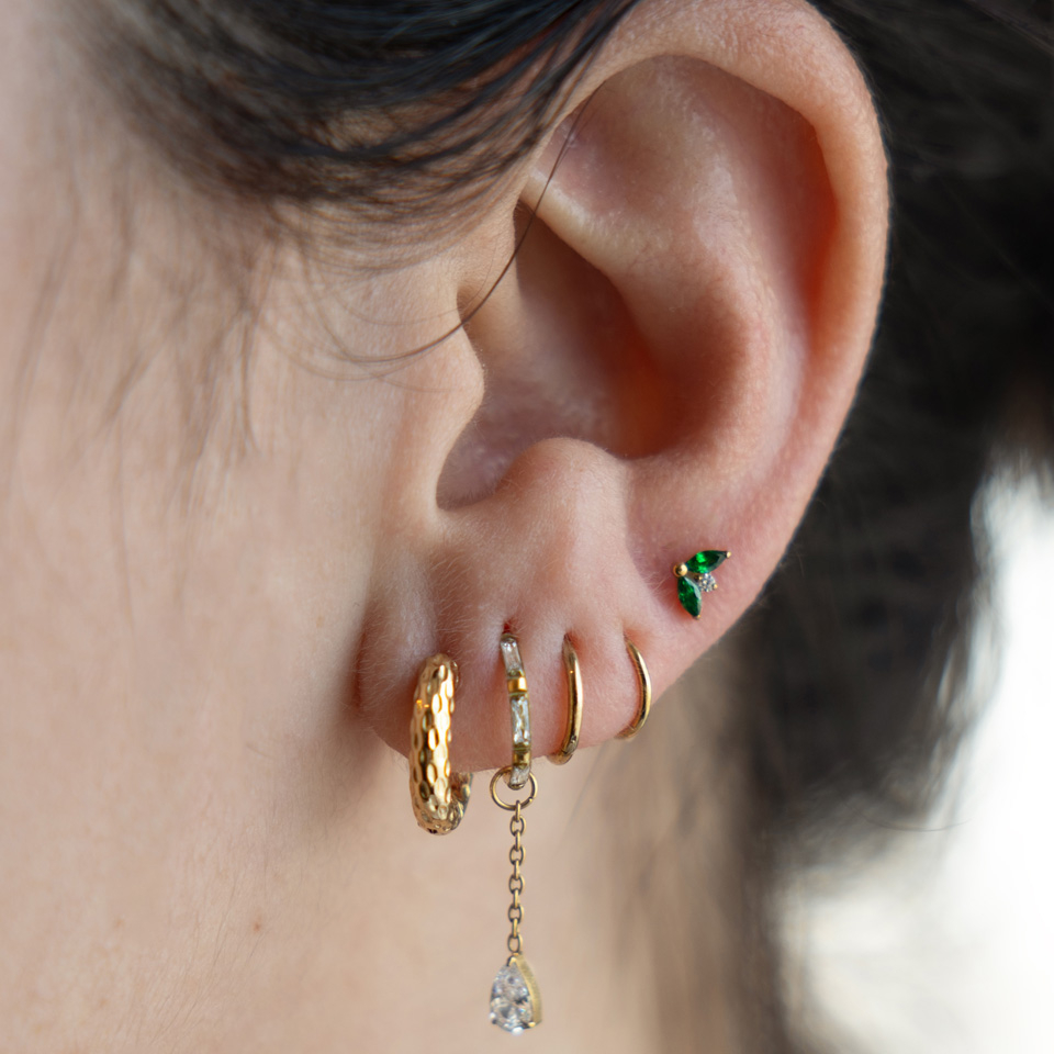 Titanová labreta s dvojicí smaragdových kamínků